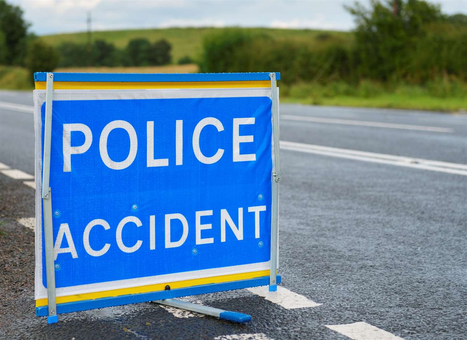 A police accident sign set up at the side of a main road.