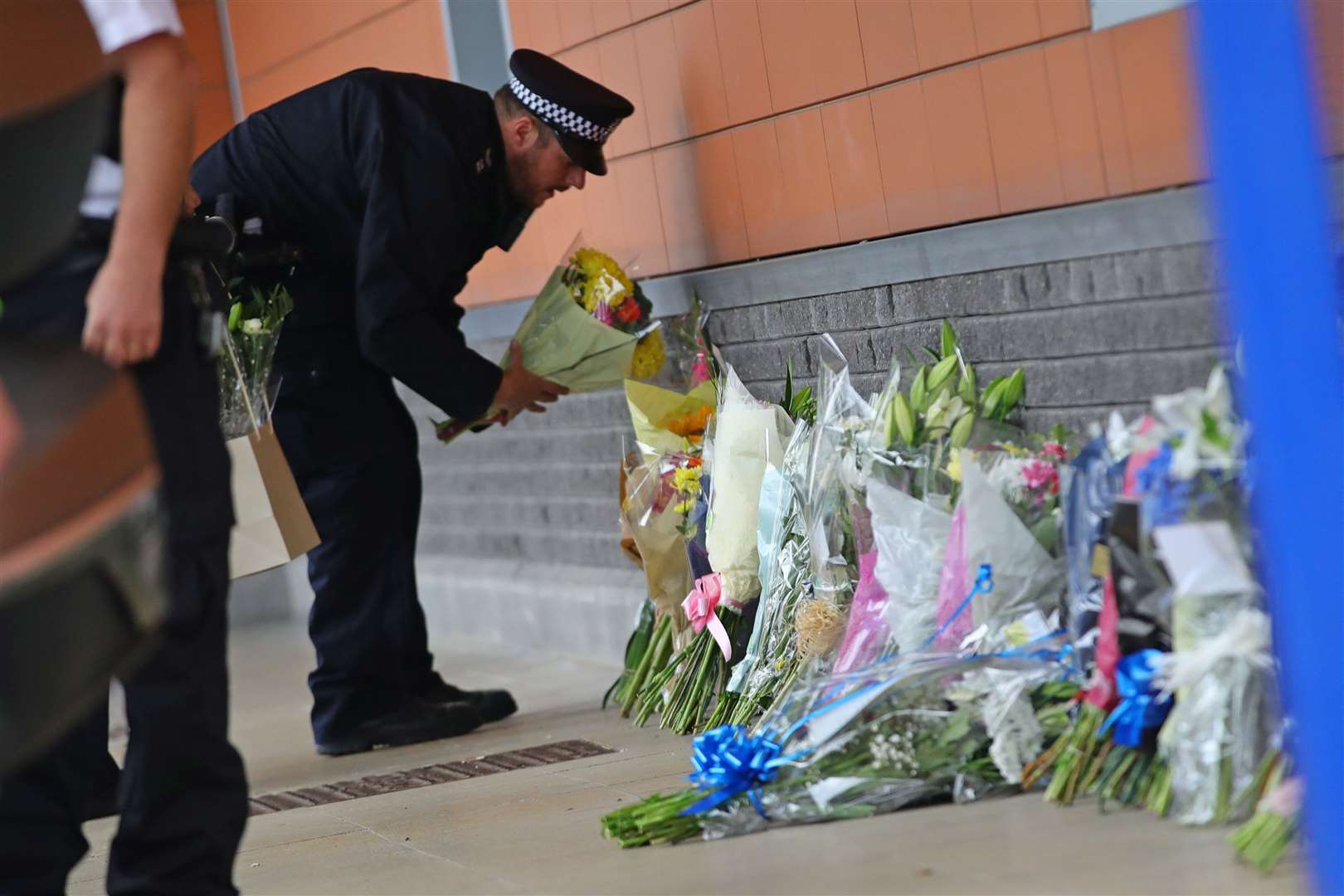A police officer lays flowers outside Croydon Custody Centre (Aaron Chown/PA)