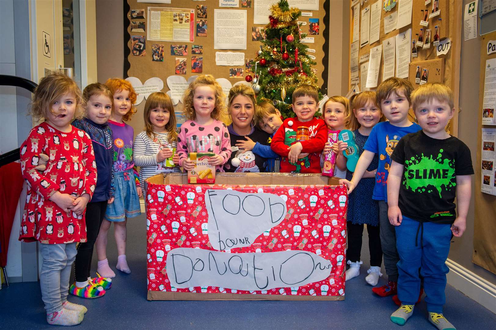 Les Enfants staff member Eilidh Mackenzie with some of the children from the Westfield nursery with their food donation box. Picture: Callum Mackay