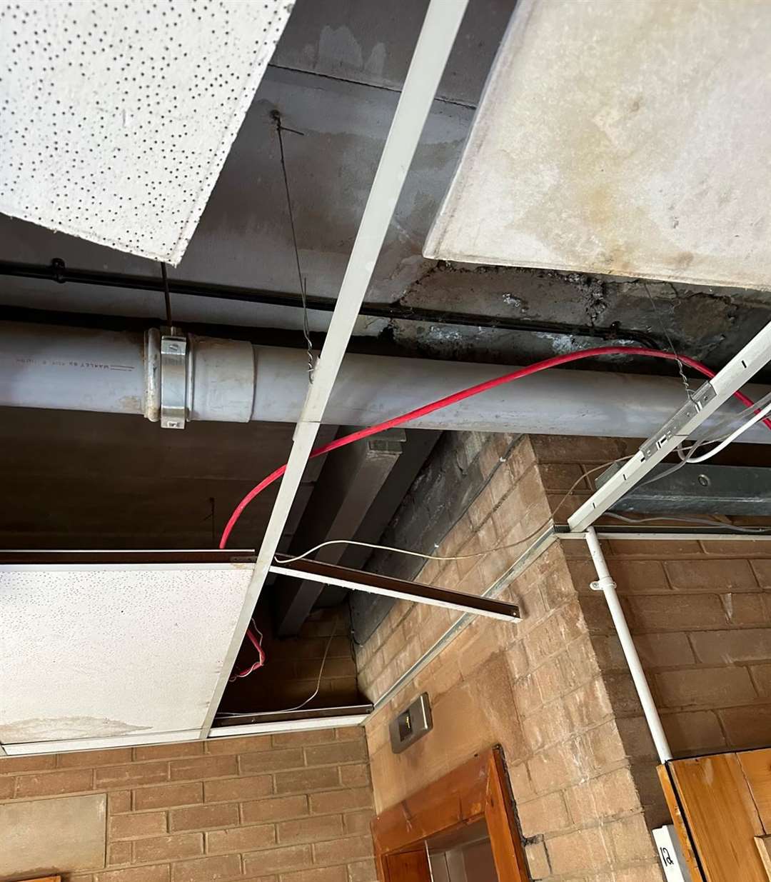 Ceilings are non-existent in some parts with exposed wiring and pipes.