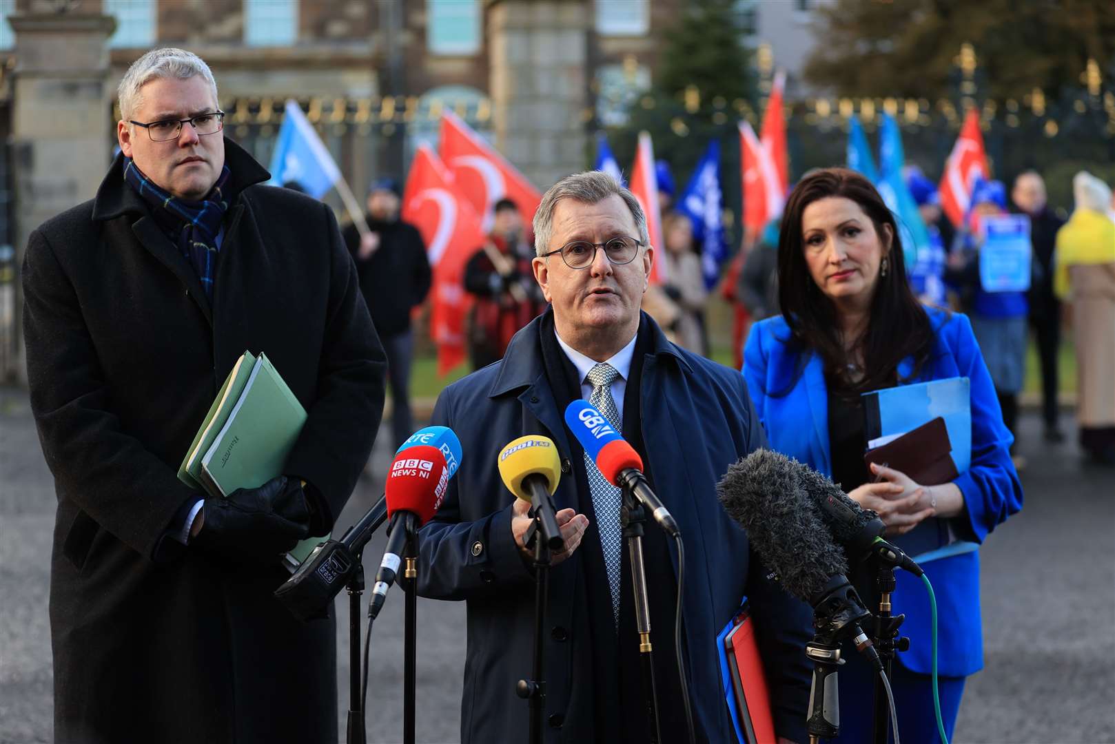 DUP leader Sir Jeffrey Donaldson (centre) speaking to the media with Emma Little-Pengelly and Deputy Leader of the DUP Gavin Robinson outside Hillsborough Castle (Liam McBurney/PA)