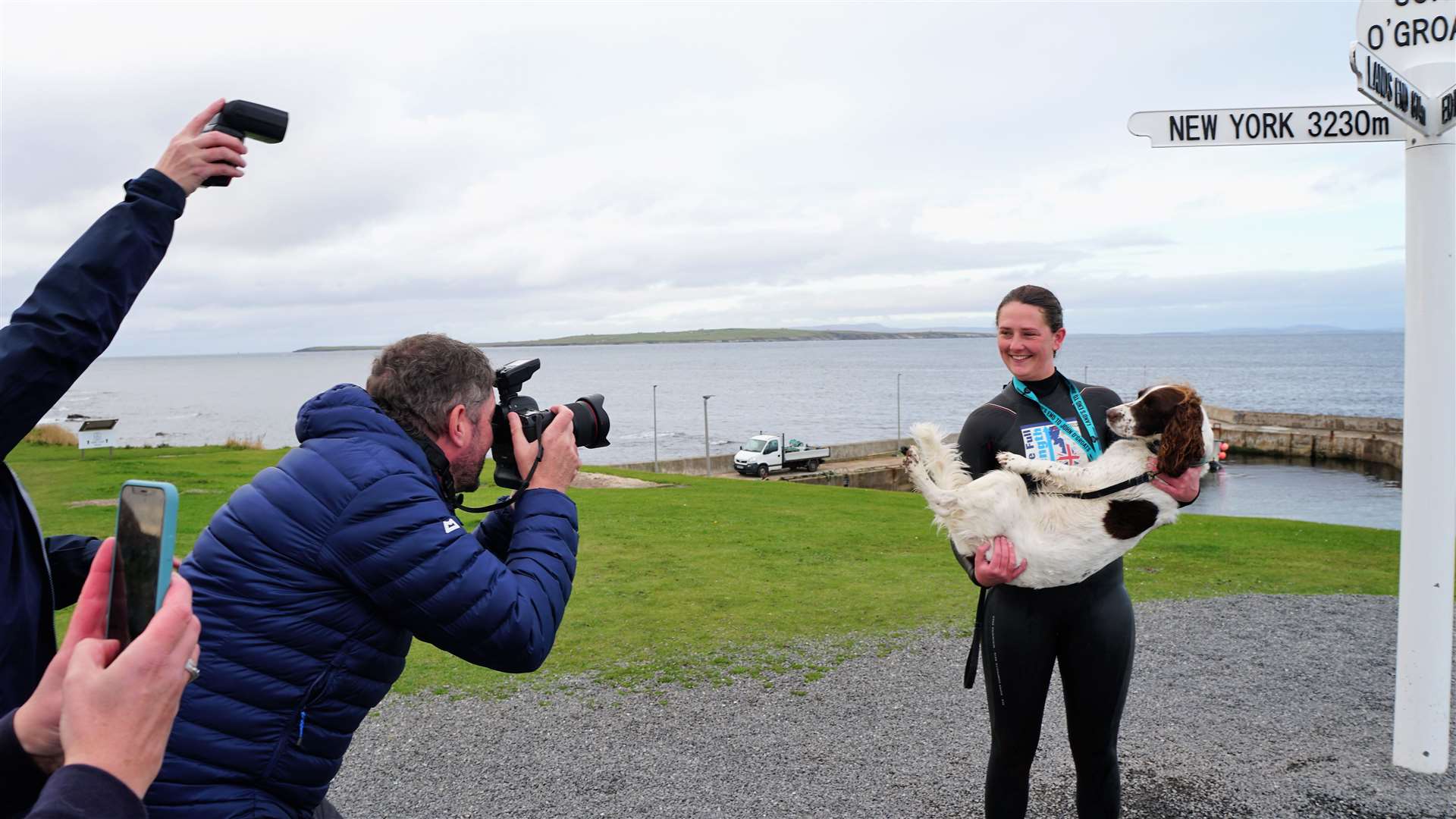 Jasmine with Bonnie the dog and media personnel at the John O'Groats fingerpost. Picture: DGS