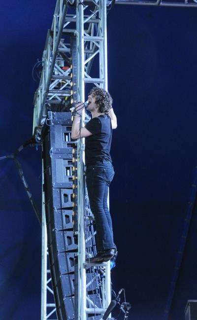 Lead singer Andrew Metcalfe ends Sound Of Guns set on a high by scaling lighting tower.