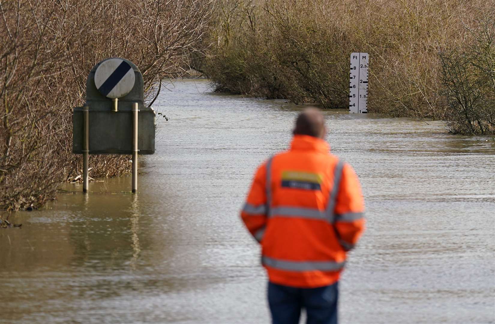 A local resident looks along the flooded A1101 in Welney, Norfolk, this week (Joe Giddens/PA)