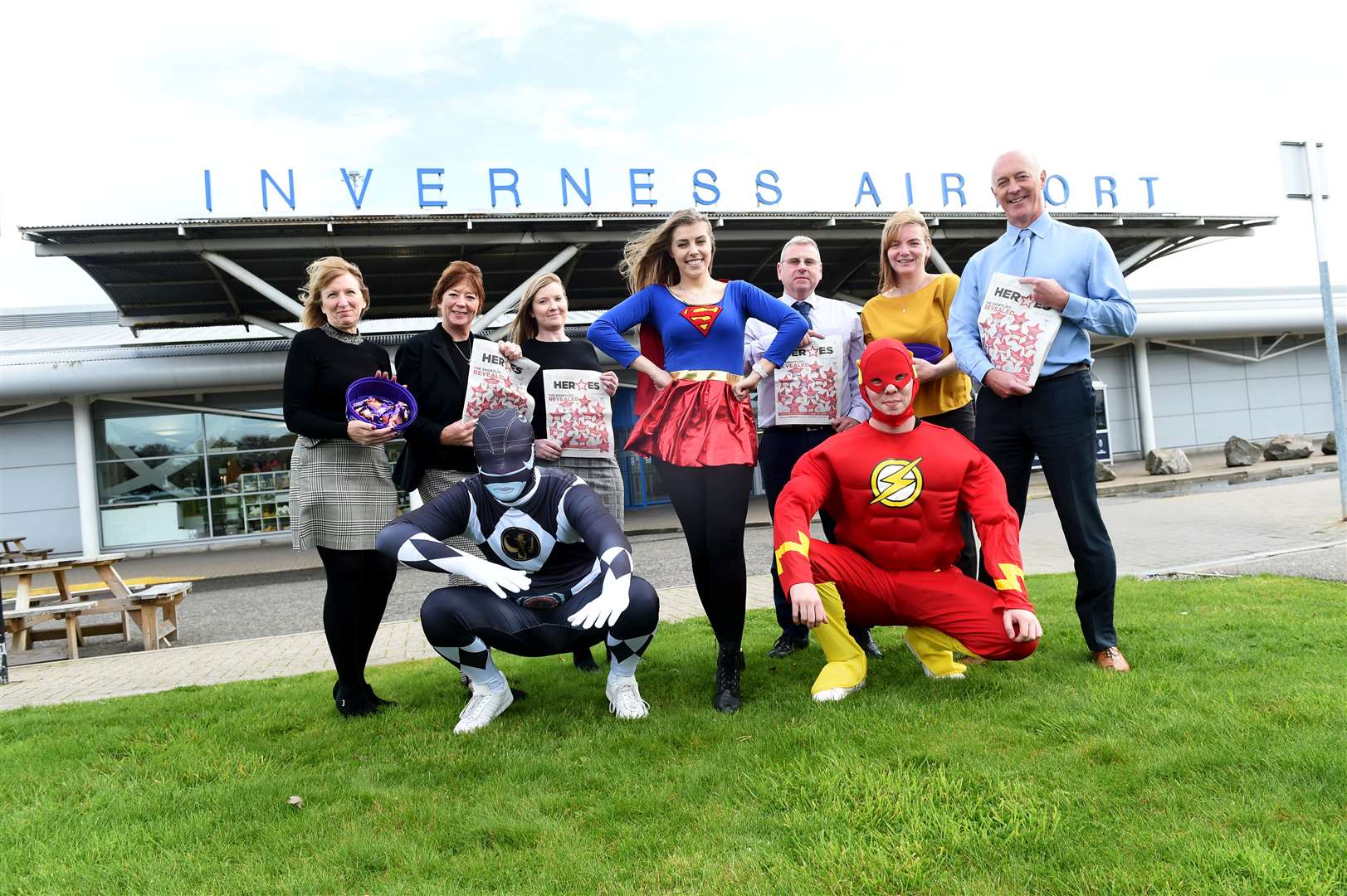 Sweets and newspaper supplements were handed out by superheroes, with help from some Inverness Airport staff.