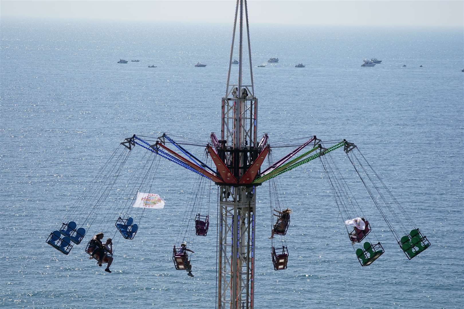 People enjoying the warm weather on a fairground ride at Boscombe beach (Andrew Matthews/PA)