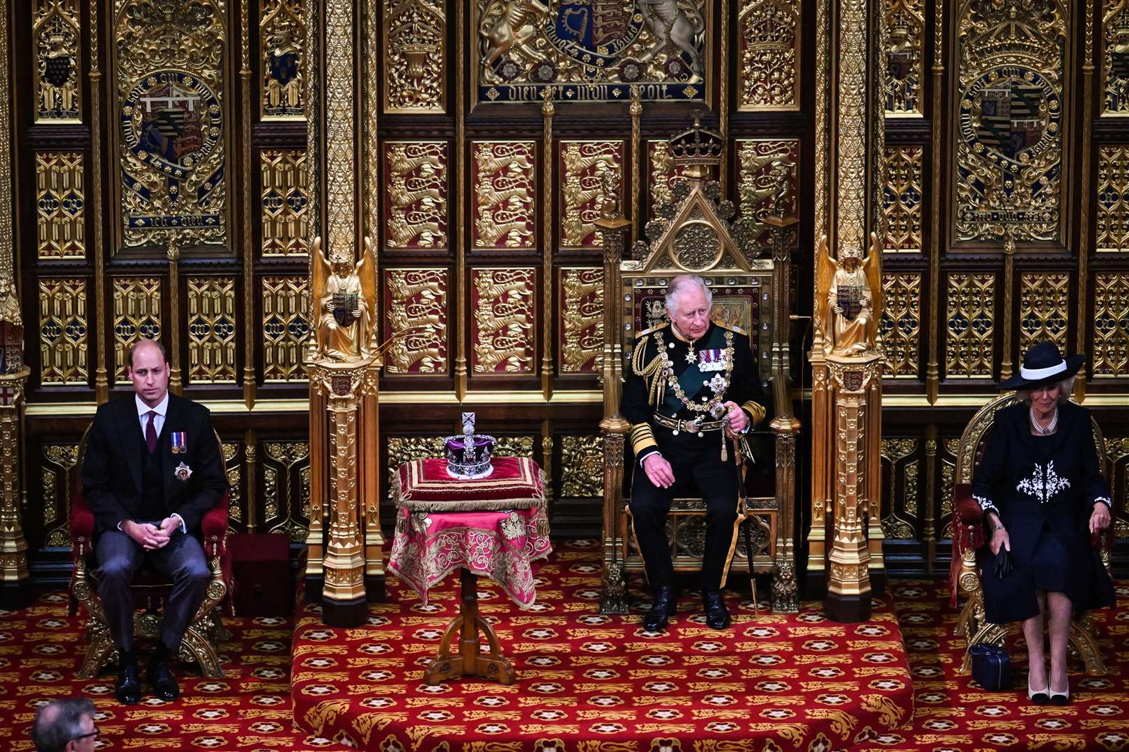 The Prince of Wales sits by the Imperial State Crown with the Duke of Cambridge on his right and the Duchess of Cornwall on his left during the State Opening of Parliament (Ben Stansall/PA)