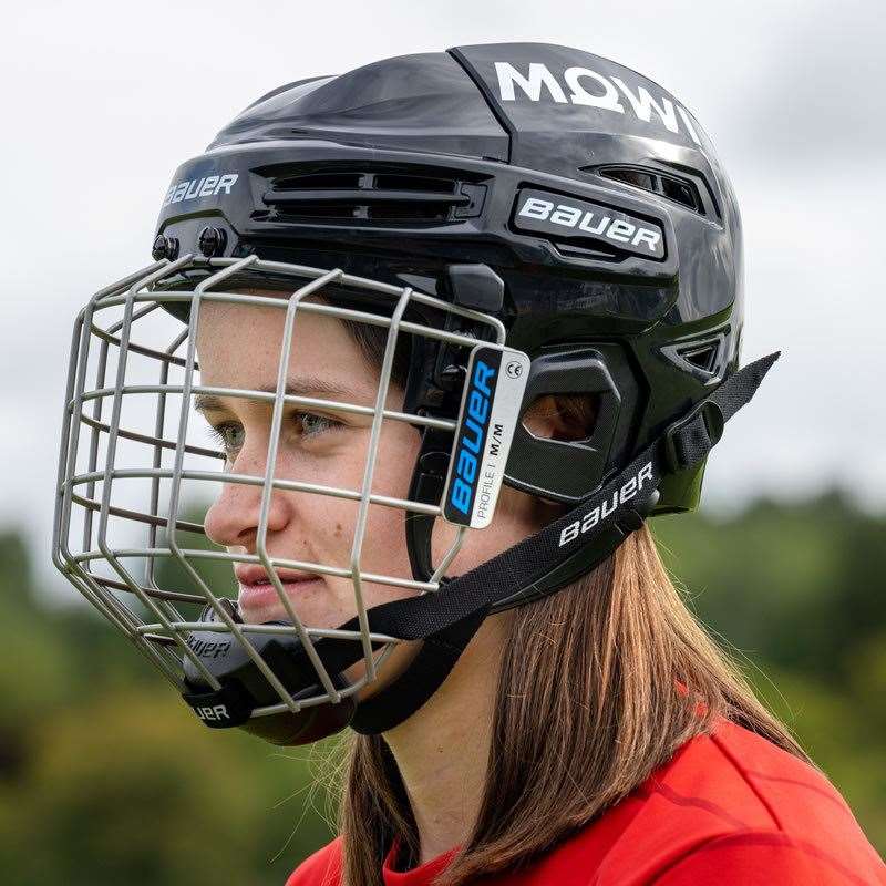 A young shinty player tries on the new helmet
