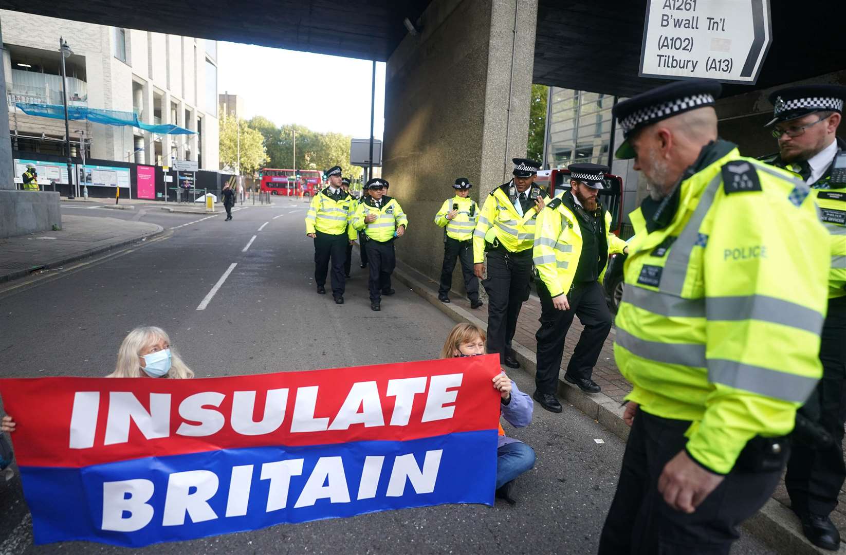 Protesters from Insulate Britain block a road near Canary Wharf in east London (Victoria Jones/PA)