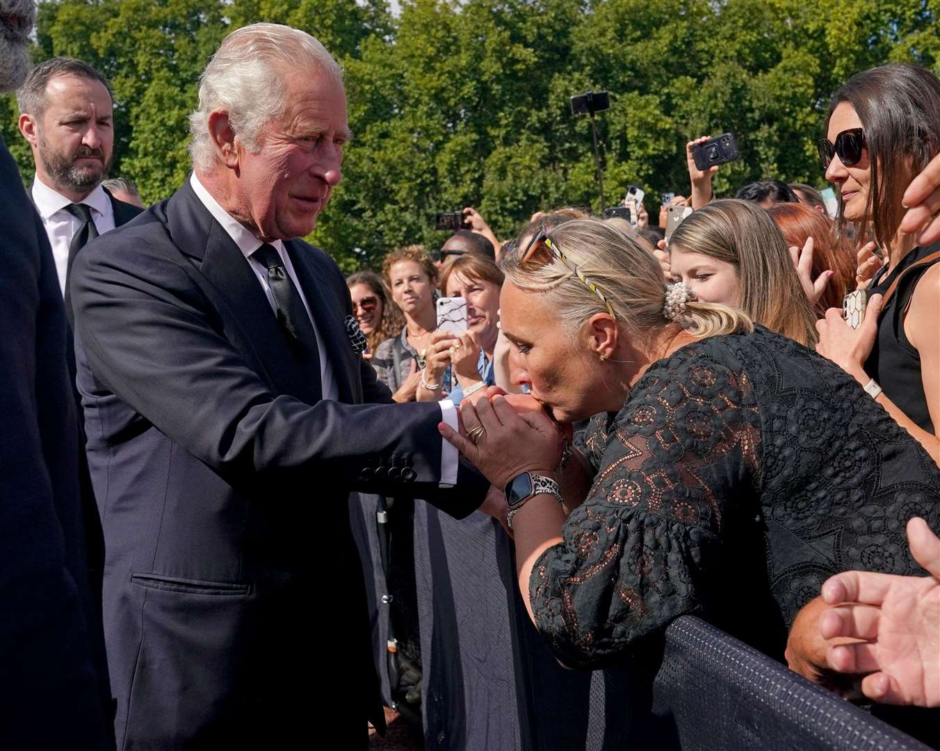 A well-wisher kisses the hand of King Charles III during a walkabout outside Buckingham Palace to view messages and tributes (Yui Mok/PA)