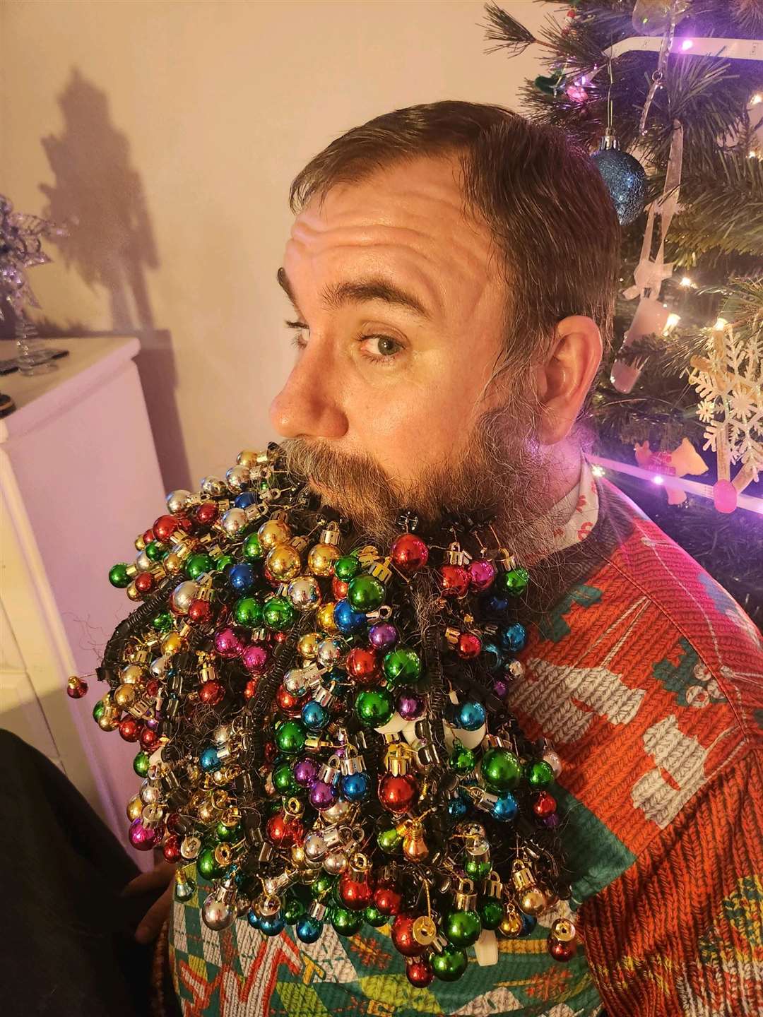 Joel Strasser attached 710 baubles to his beard, a world record (Guinness World Records/PA)