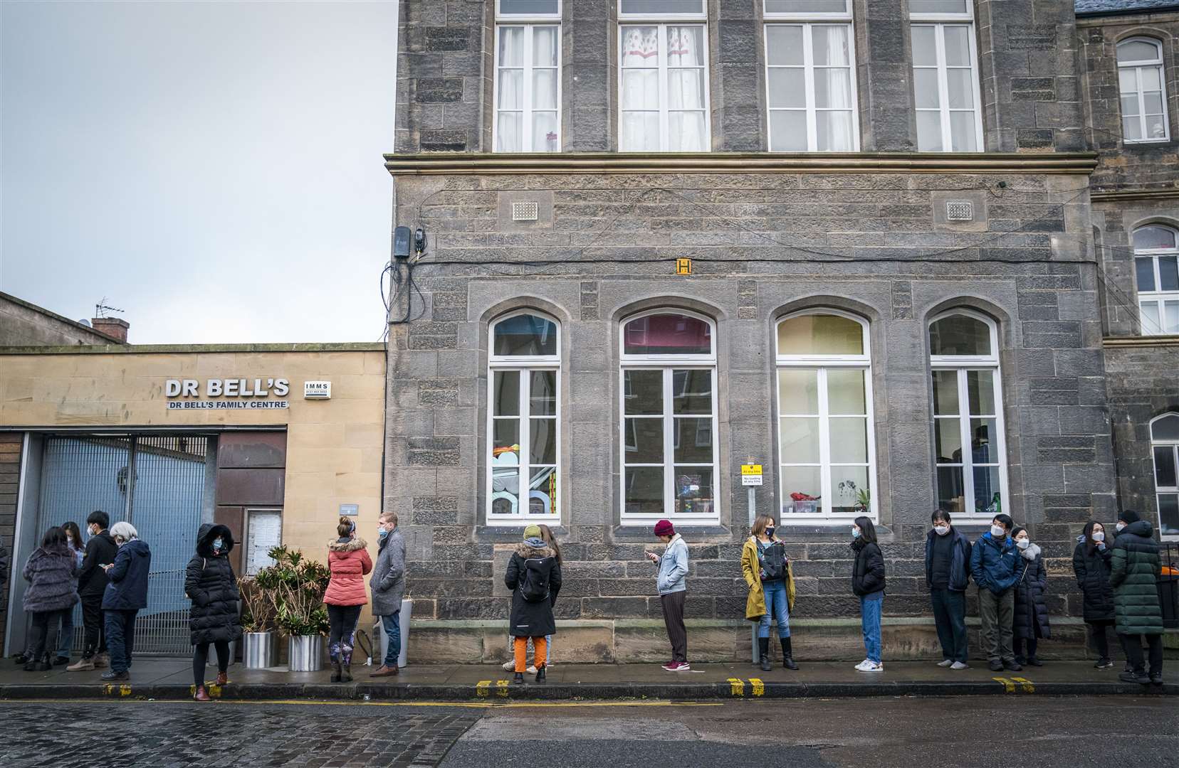 People queue along Junction Place, Edinburgh, for the vaccination centre at the NHS Scotland Leith Community Treatment Centre, as the coronavirus booster vaccination programme is ramped up (Jane Barlow/PA)