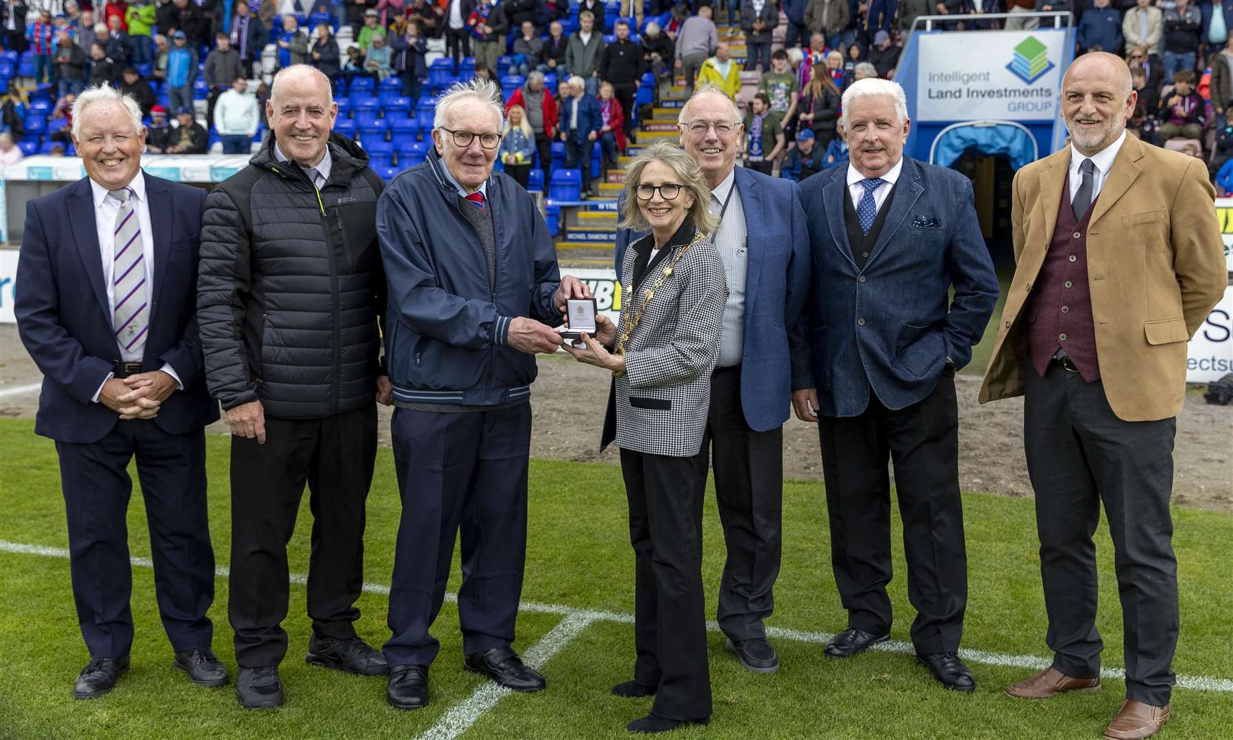 Jackie Sutherland is presented with the City of Inverness medal from Inverness Provost Glynis Campbell-Sinclair, in recognition of his lifetime of service to youth football in the city. Picture by Ken Macpherson