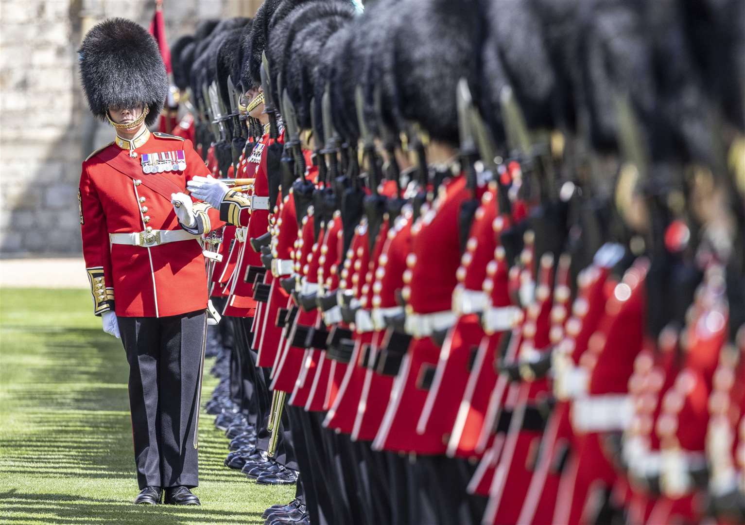 A warrant officer of the 1st Battalion Irish Guards makes sure the line of guardsmen is straight as the regiment lines up on parade in the Quadrangle (Richard Pohle/The Times/PA)