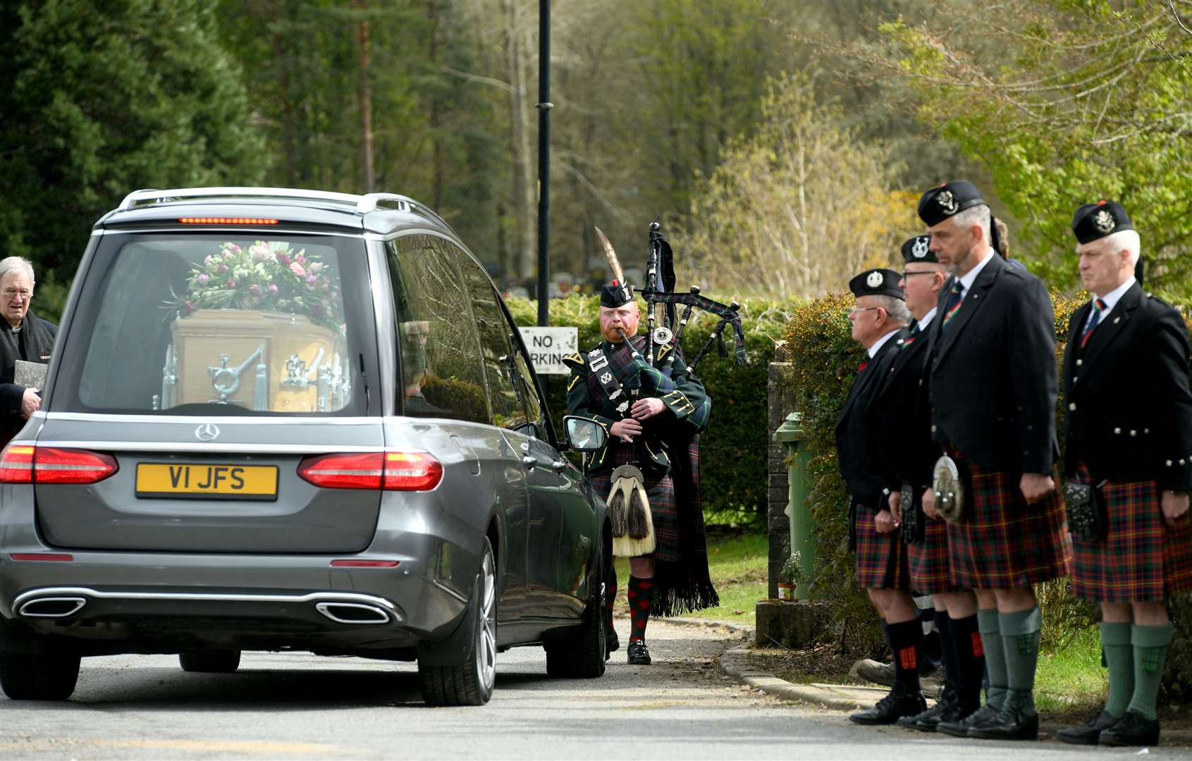 Pipers pay their respects as the funeral procession arrives at Kilvean Cemetery.