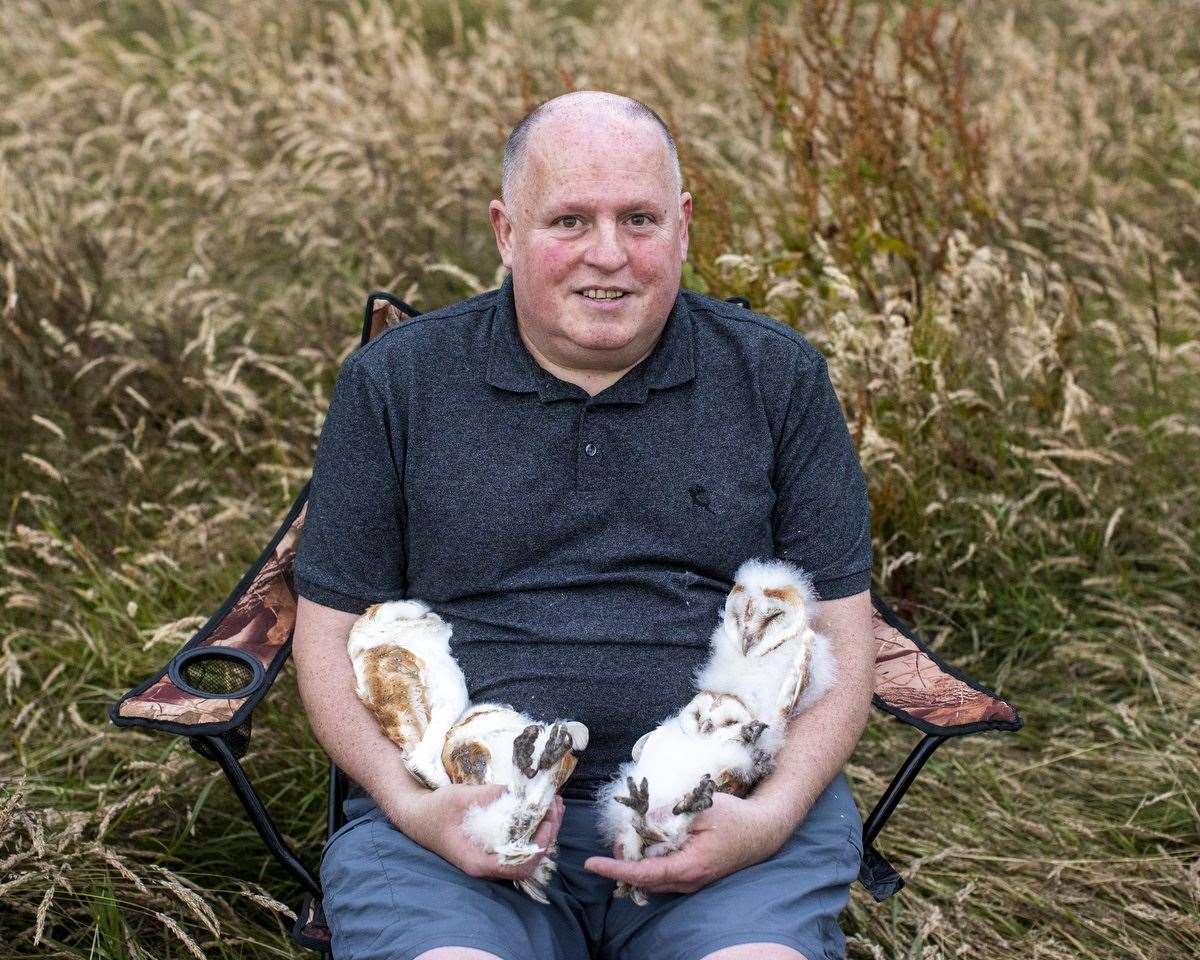 Volunteer nest minder Ciaran Walsh holding the four owlets after they were ringed close to the shores of Lough Neagh in Crumlin, Co Antrim (Liam McBurney/PA)