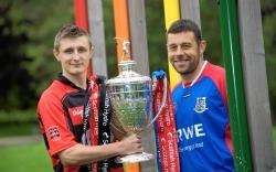 Fraser Heath (Glen) and Kingussie's James Hutchison with the Camanachd Cup. Picture: Callum Mackay.