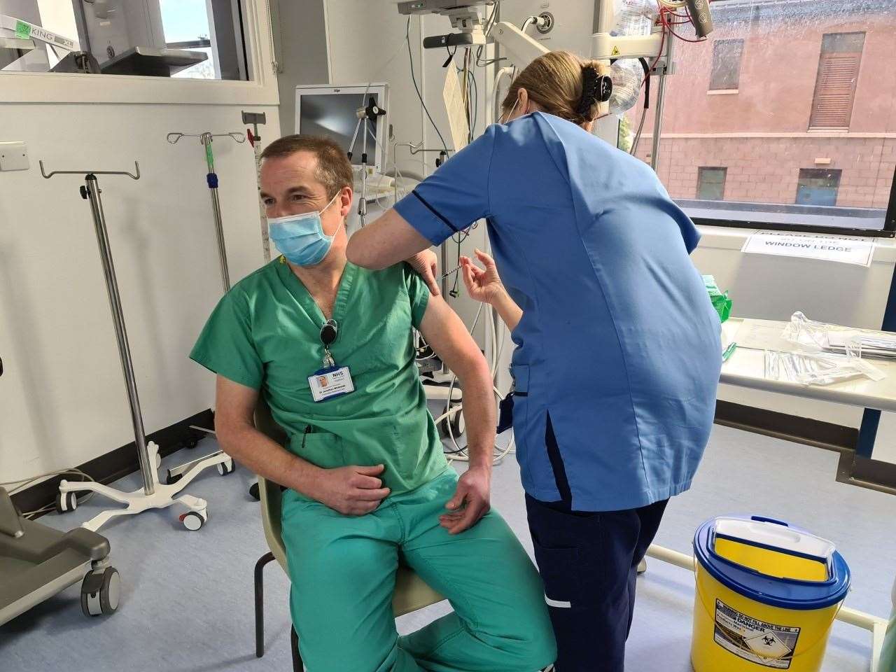 Dr Jonathan Whiteside, clinical lead for critical care with NHS Highland, is the first person to be vaccinated within the NHS Highland area. Maureen Sutherland is administering the vaccine.