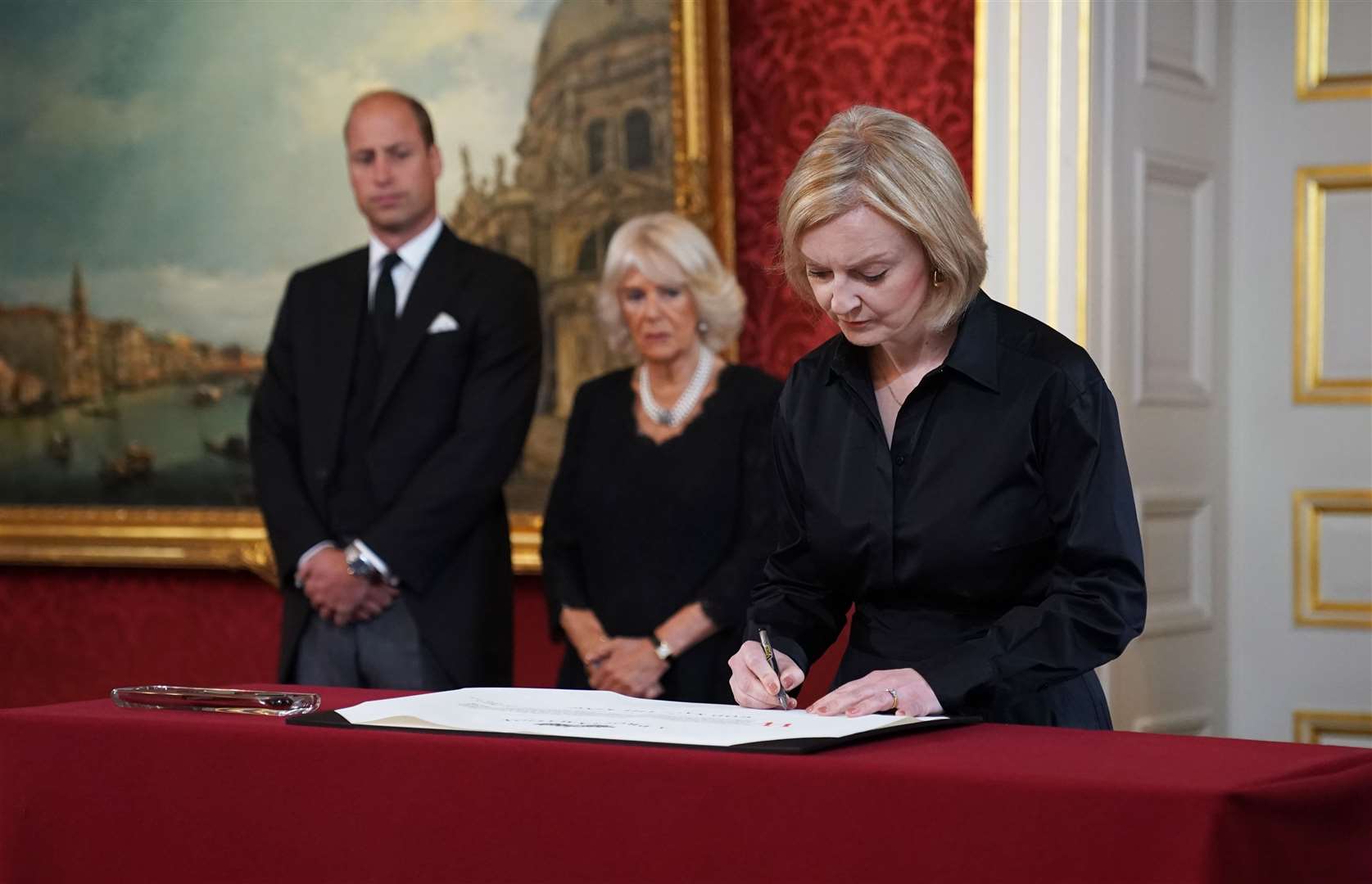 Prime Minister Liz Truss signs the Proclamation of Accession of King Charles III (Kirsty O’Connor/PA)