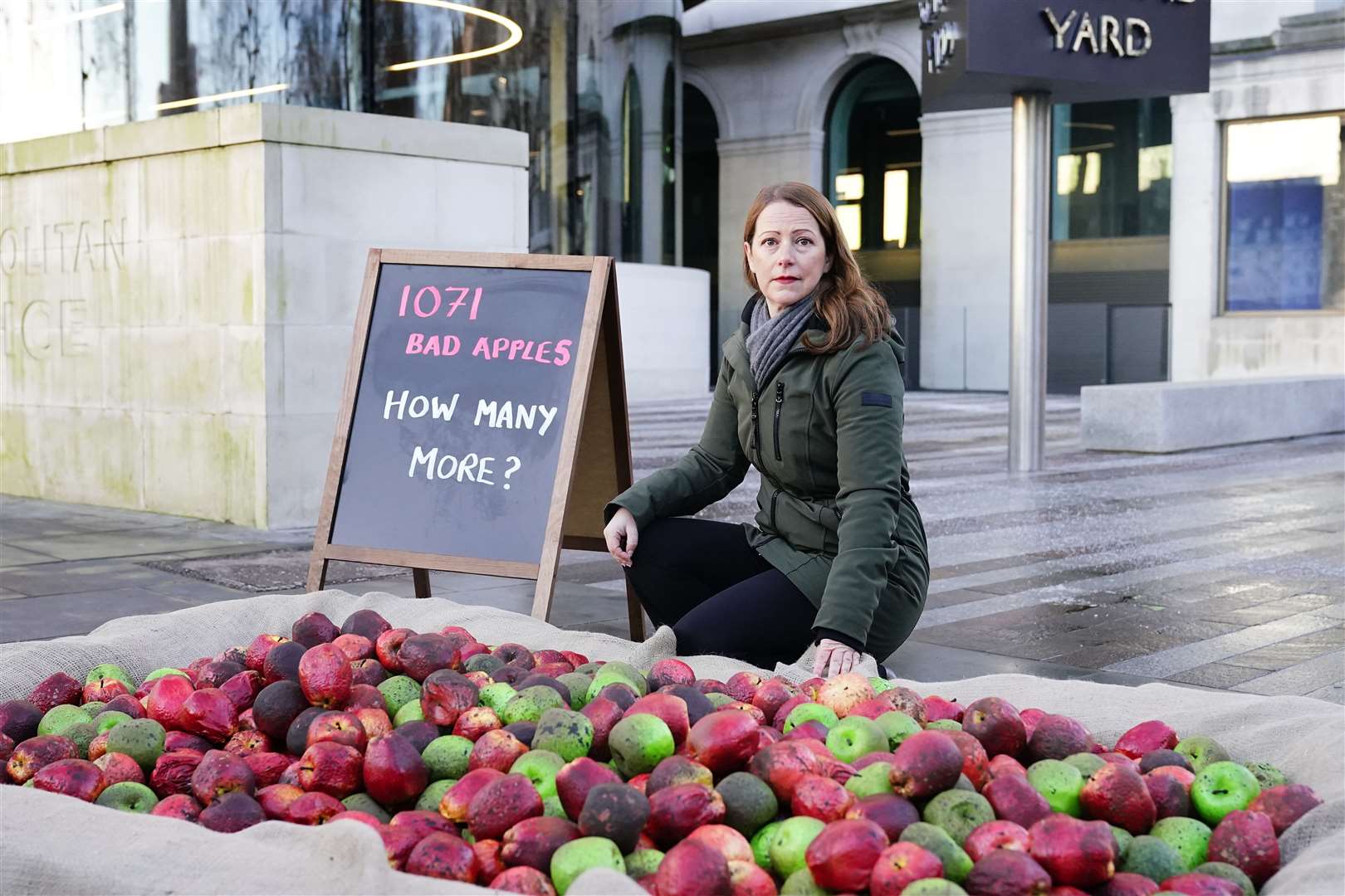 Refuge chief executive Ruth Davison helps place 1,071 rotten apples outside New Scotland Yard (Aaron Chown/PA)