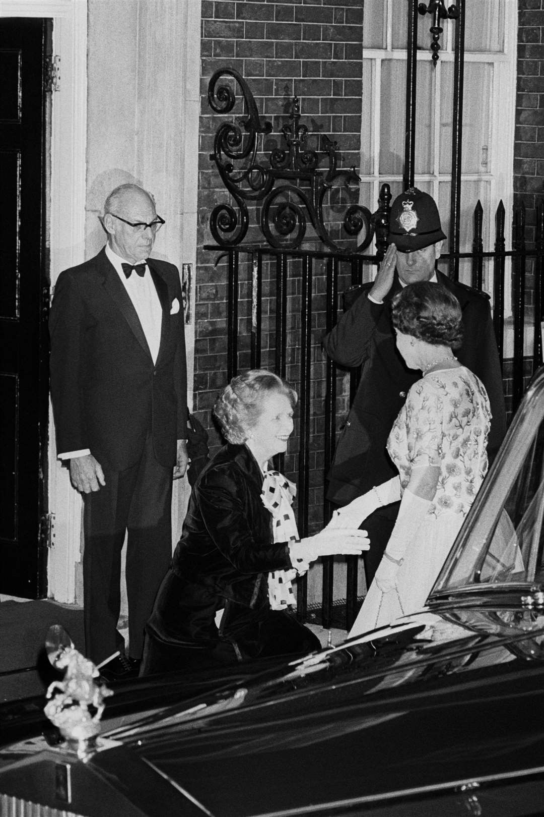 Margaret Thatcher curtseying to the Queen as she arrived for a dinner at 10 Downing Street in 1985 (PA)