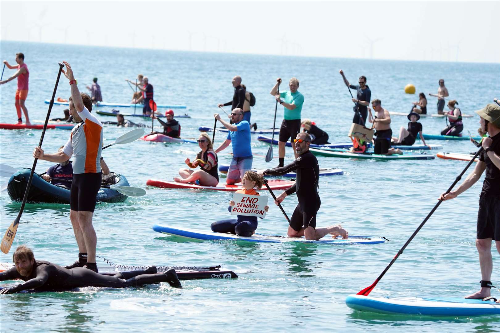 People take part in a paddle-out protest in Brighton (Gareth Fuller/PA)