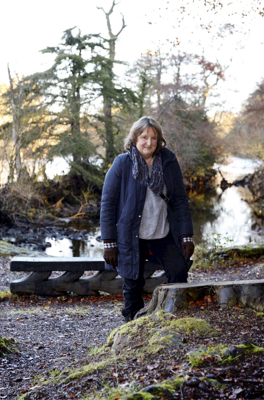Helen Smith of OpenNess beside a tree stump at the site of the children's water feature.