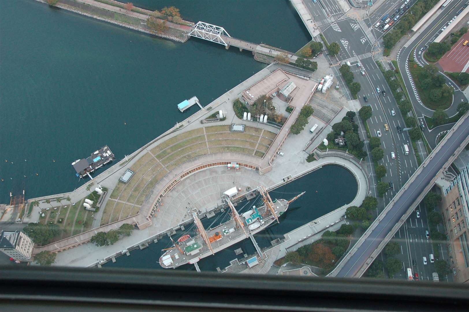 A view of the port area from the 69th floor of the Sky Tower, with the crescent of the Port Museum and the Nippon Maru sail training ship.