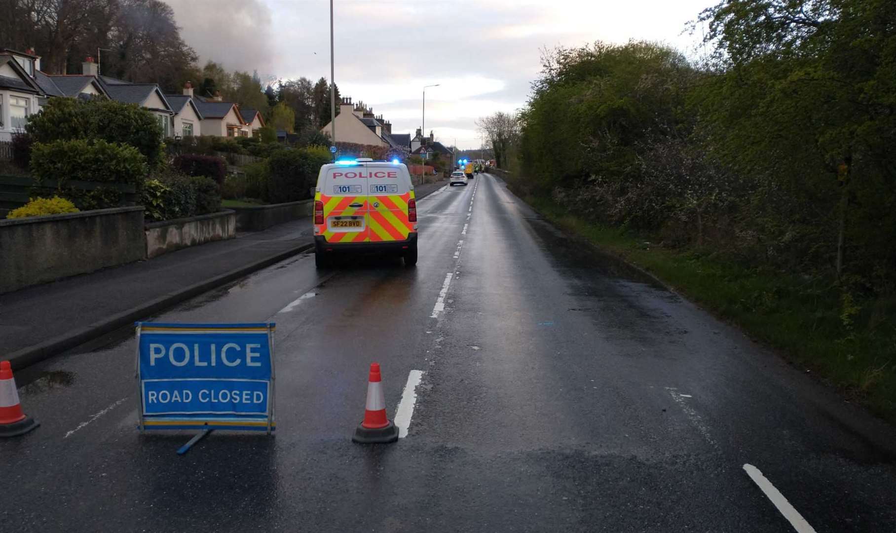 Police road block on Clachnaharry Road after fire overnight, with smoke visible in distance.
