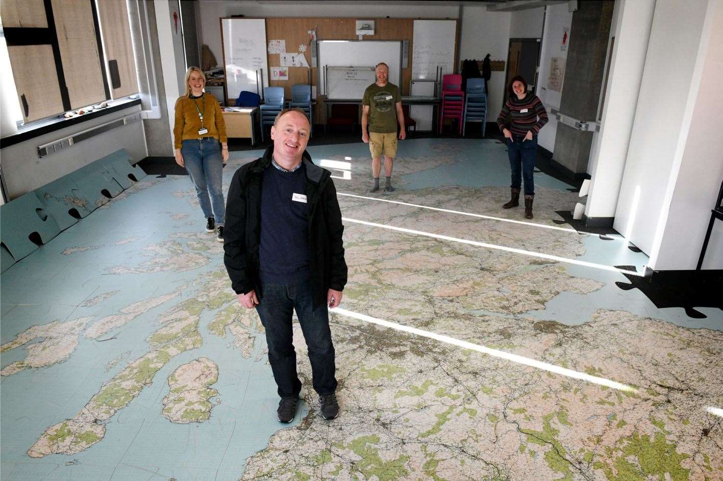 Teachers standing on their home towns on the giant jigsaw OS map of Scotland – Shetland was out in the corridor.