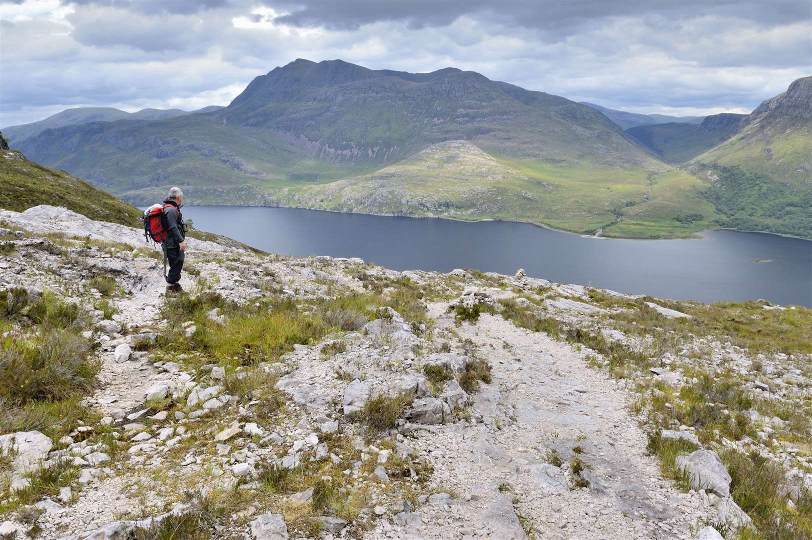 A hillwalker enjoying the view over Loch Maree from the mountain trail at Beinn Eighe National Nature Reserve, Wester Ross.