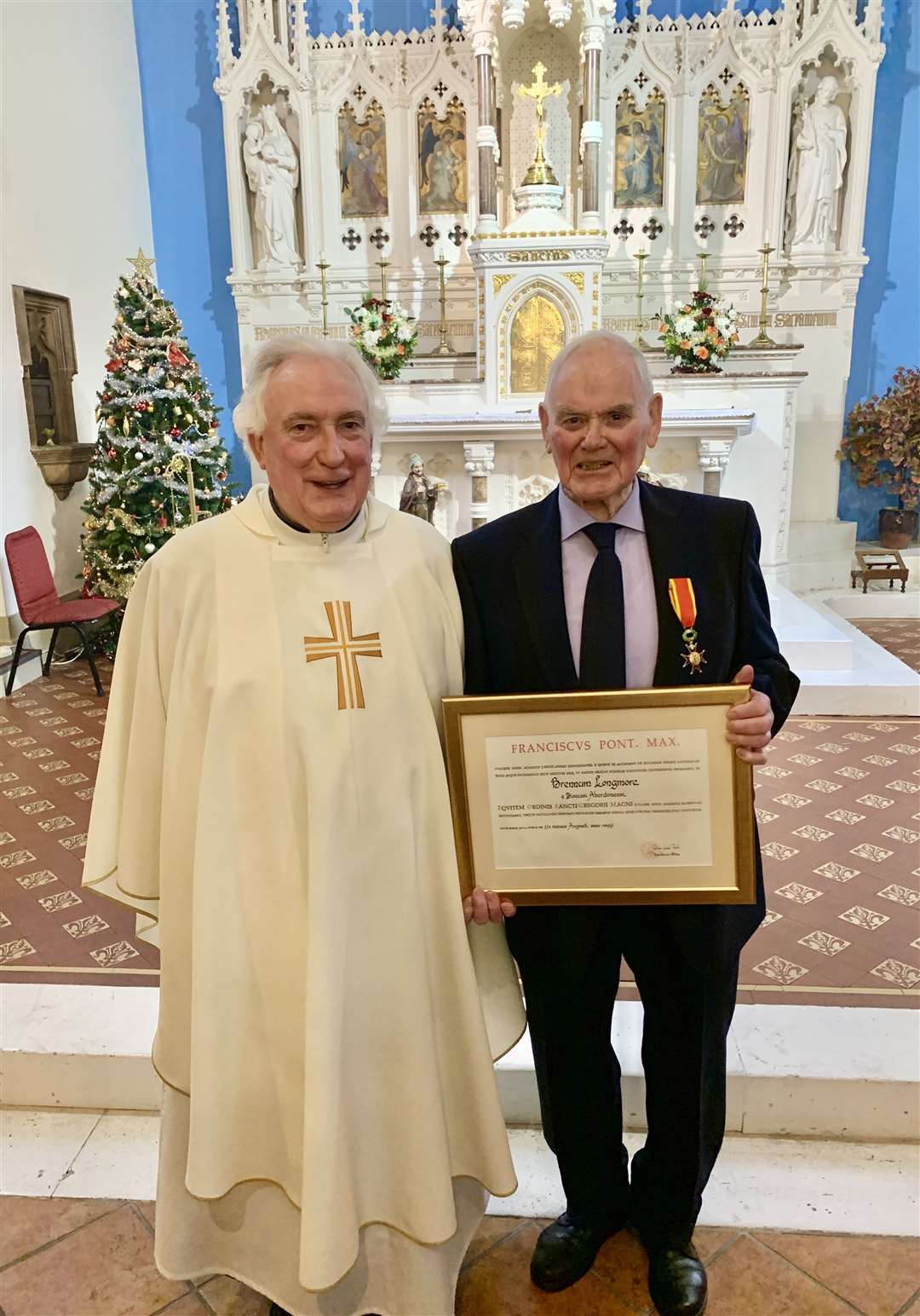 Bryan Longmore with parish priest Father James Bell after being awarded a papal knighthood.
