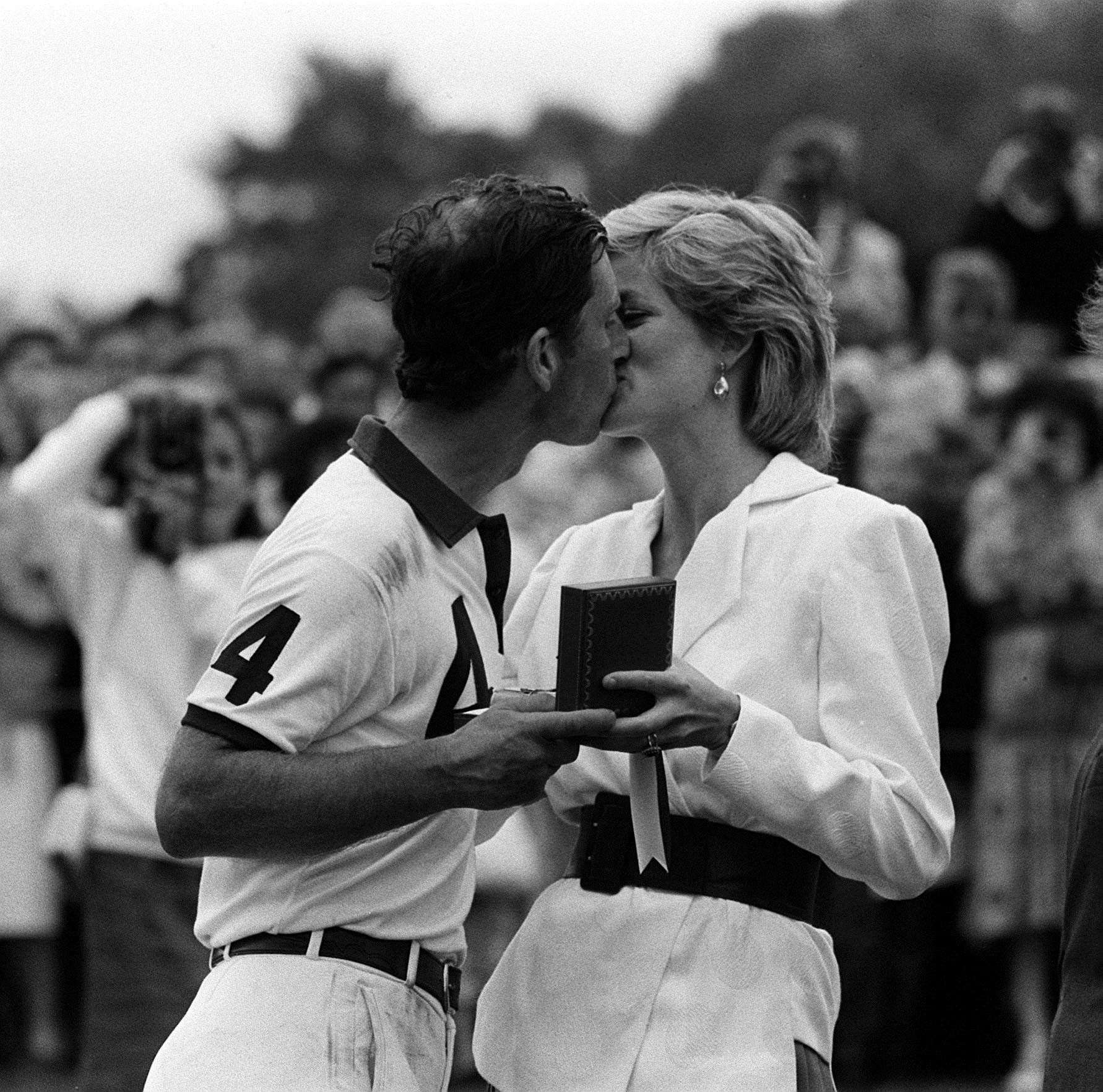 The Princess of Wales presenting her husband, the Prince of Wales, with a prize and a kiss after a polo match in 1986 (Ron Bell/PA)