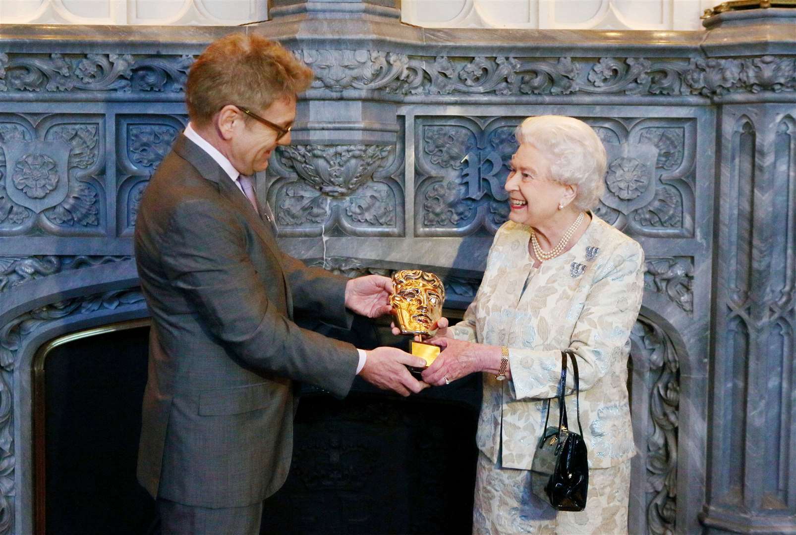 The Queen receives an honorary Bafta from Sir Kenneth Branagh for a lifetime’s support of British film and television in 2013 (Steve Parsons/PA)