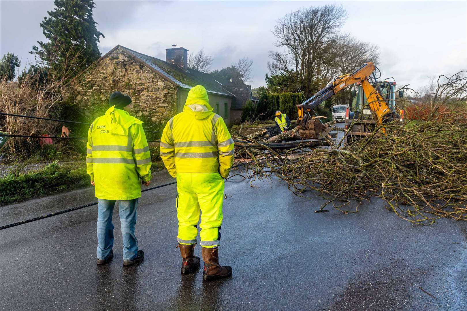 Cork County Council and ESB employees help clear the road and restore power in Timoleague, West Cork (Andy Gibson / PA)