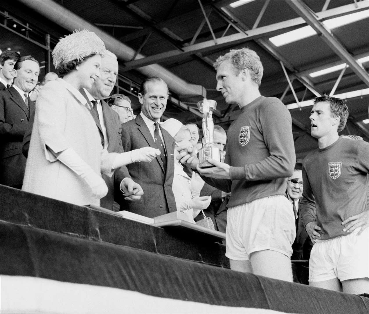 The Queen hands the Jules Rimet Trophy to England captain Bobby Moore in 1966 (PA)