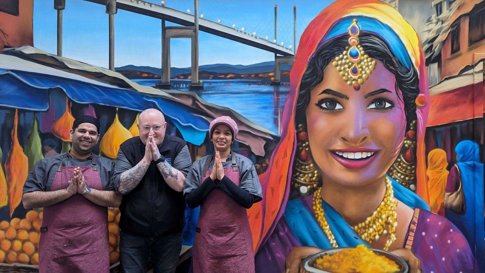 Cameron MacFarlane alongside the staff at Namaste standing in front of the new mural in the Victorian Market.