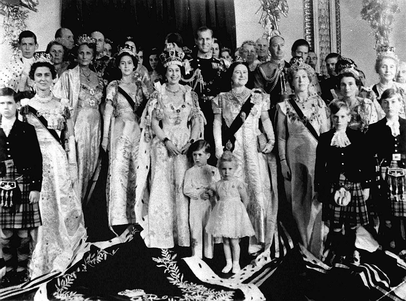 Queen Elizabeth II, the Duke of Edinburgh, Prince Charles, Princess Anne and family and guests pose at Buckingham Palace after the coronation (PA)