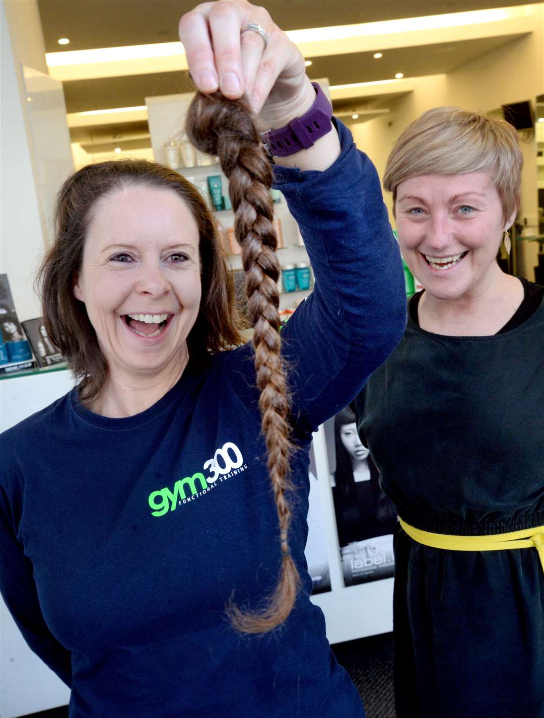 Nicola Ashmole (left) has her pony tail chopped off by Emma Martin at Toni & Guy in Inverness. Picture: Gair Fraser. Image No. 043457..