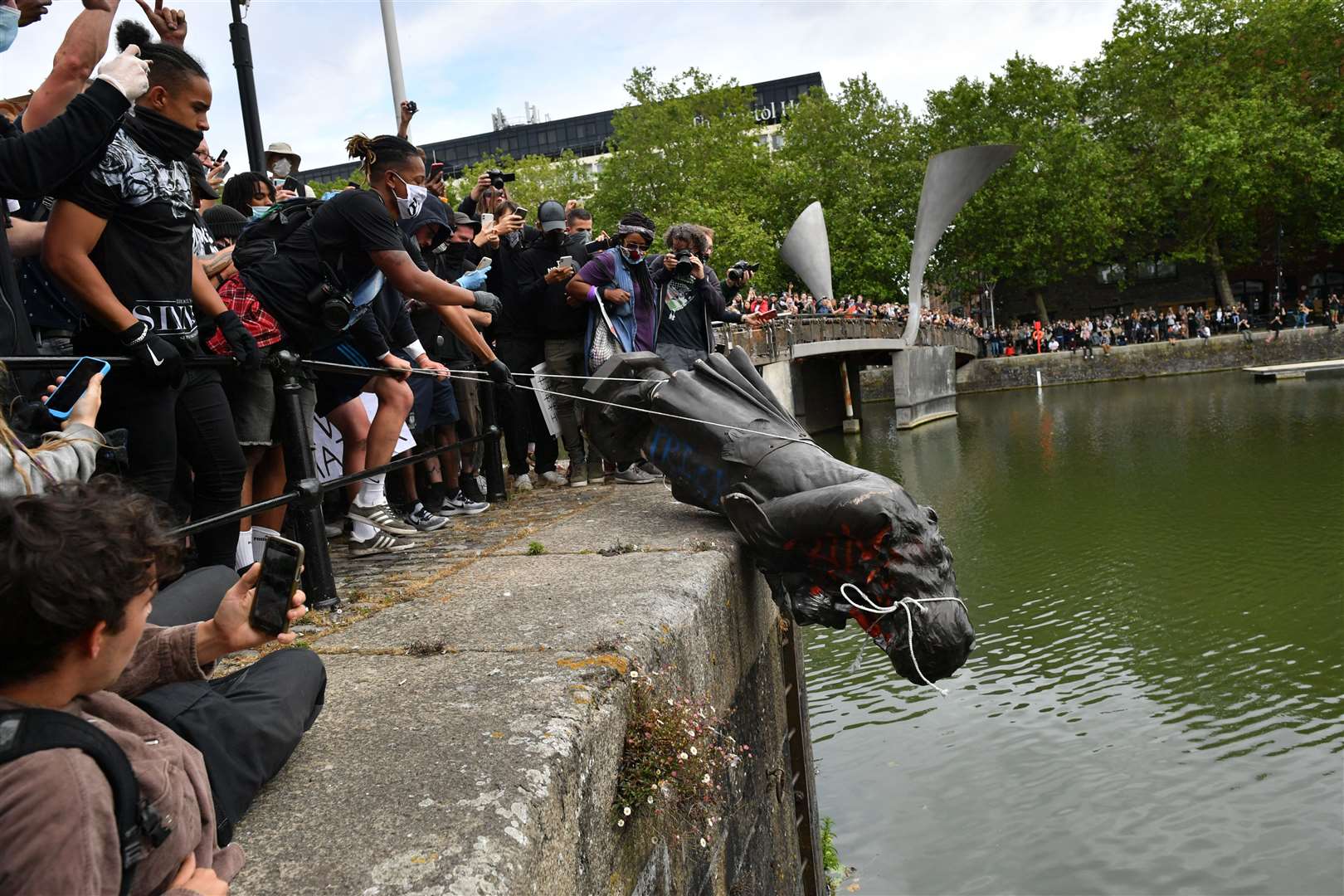 Protesters throw the statue of Edward Colston into Bristol harbour during a Black Lives Matter protest rally (Ben Birchall/PA)