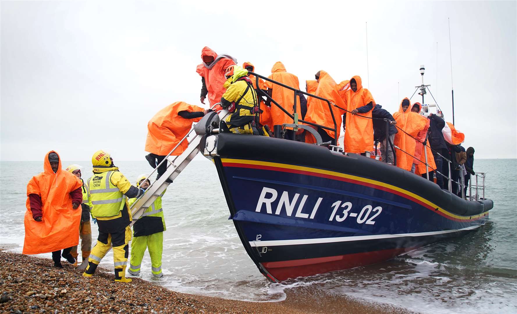 A group of people thought to be migrants are brought in to Dungeness, Kent, after being rescued by the RNLI following a small boat incident in the Channel in January (PA)