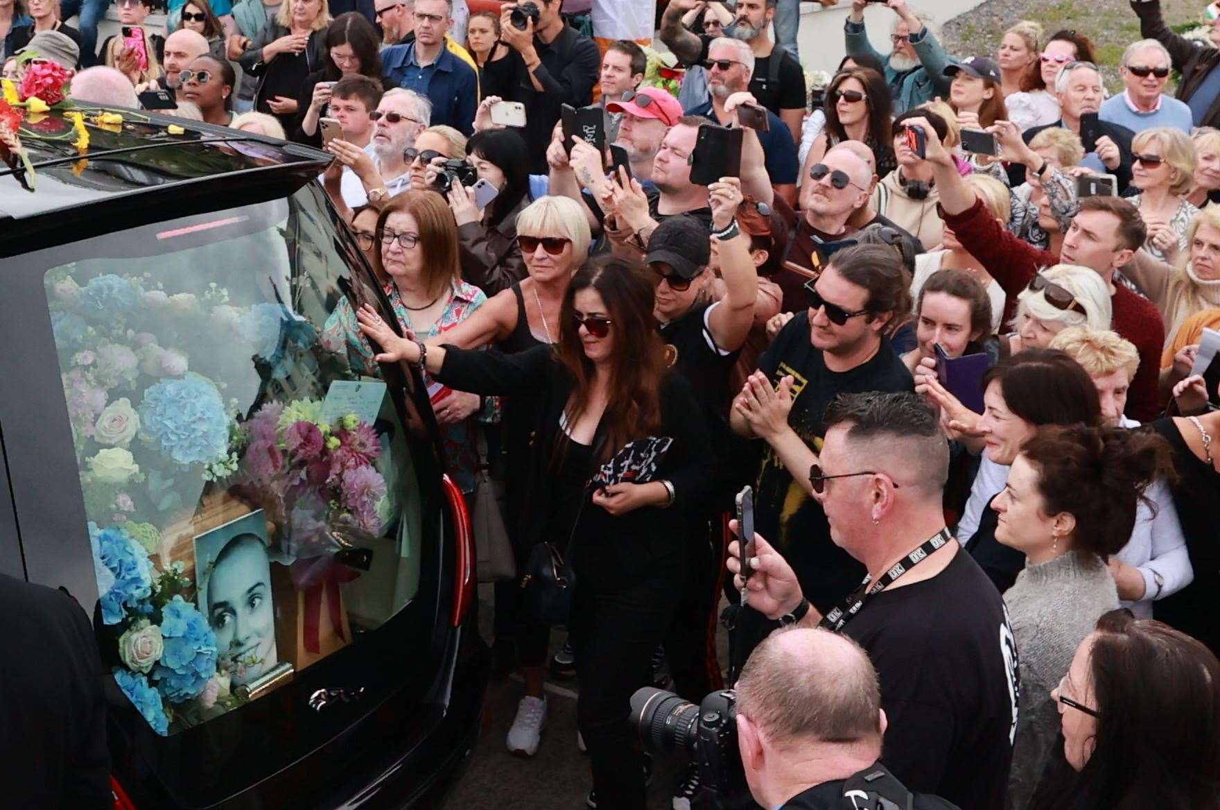 Fans of singer Sinead O’Connor line the streets for a ‘last goodbye’ to the Irish singer in Co Wicklow (Liam McBurney/PA)