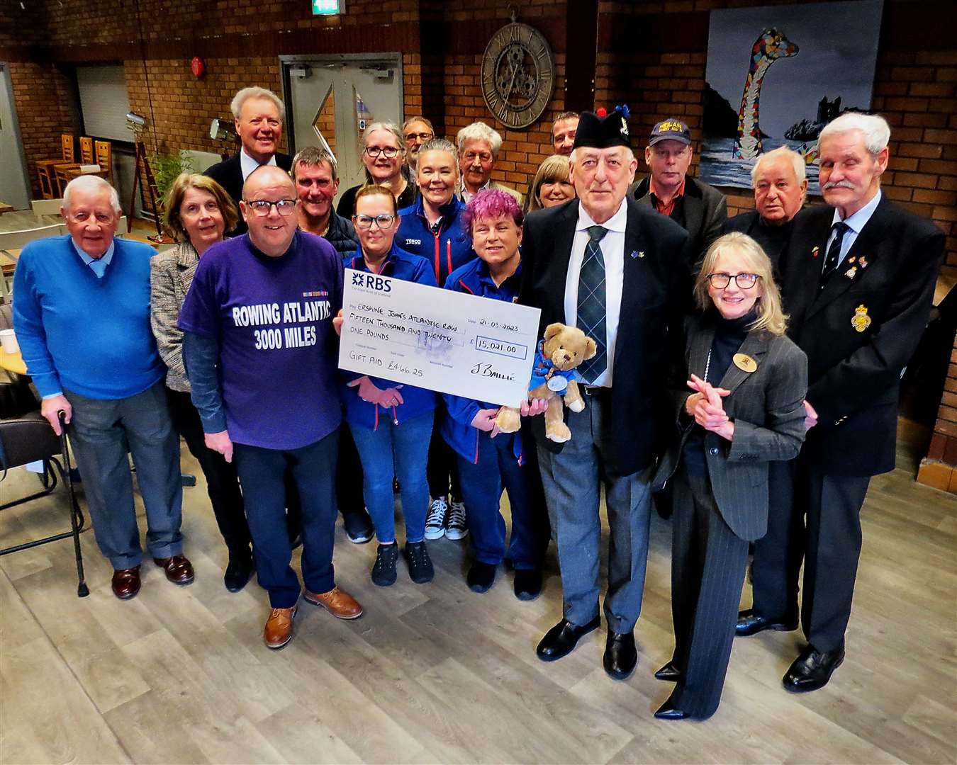 Johnnie Baillie presents a symbolic cheque for £15,021 to Erskine Hospital fundraiser Jim Watret, in the company of Inverness Provost Glynis Campbell-Sinclair, veterans, donors and members of Tesco staff who helped him in his Atlantic row.