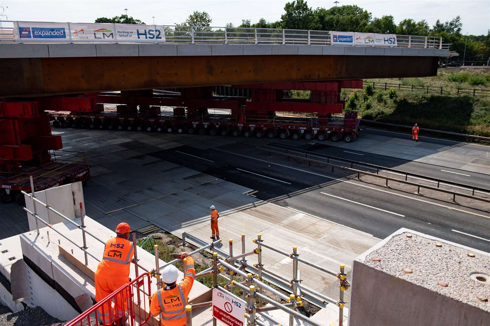 HS2 workers watch as a bridge is wheeled into position over the M42 at the HS2 interchange station site near Solihull (Jacob King/PA)