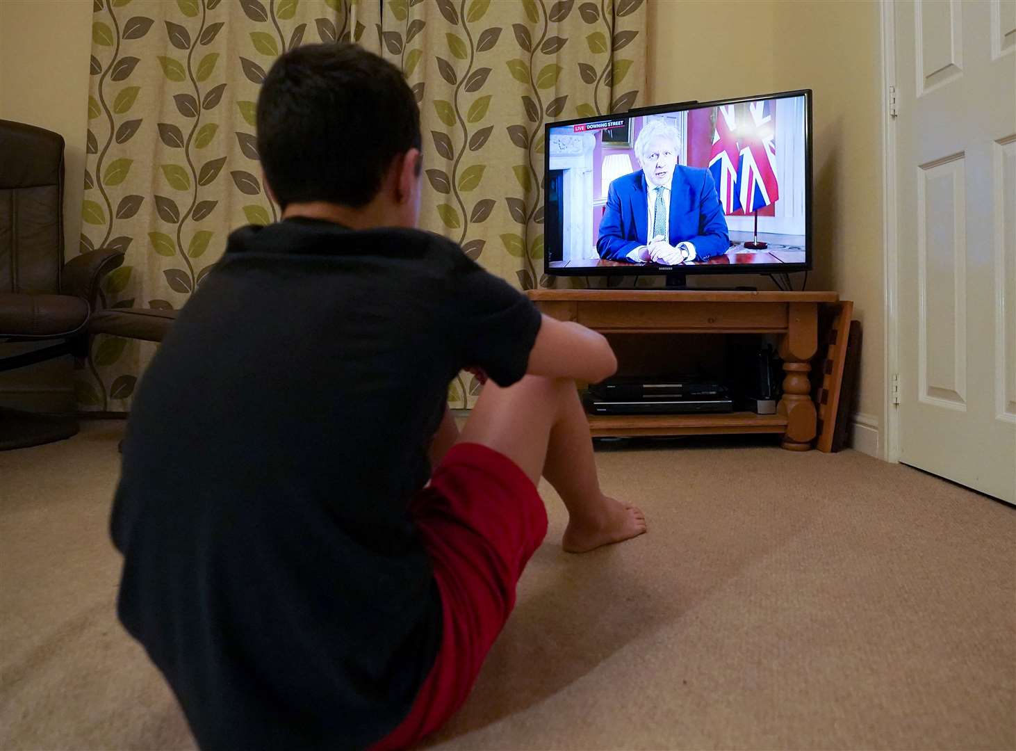 A family member in Nottingham watches Prime Minister Boris Johnson making a televised address to the nation (Zac Goodwin/PA)