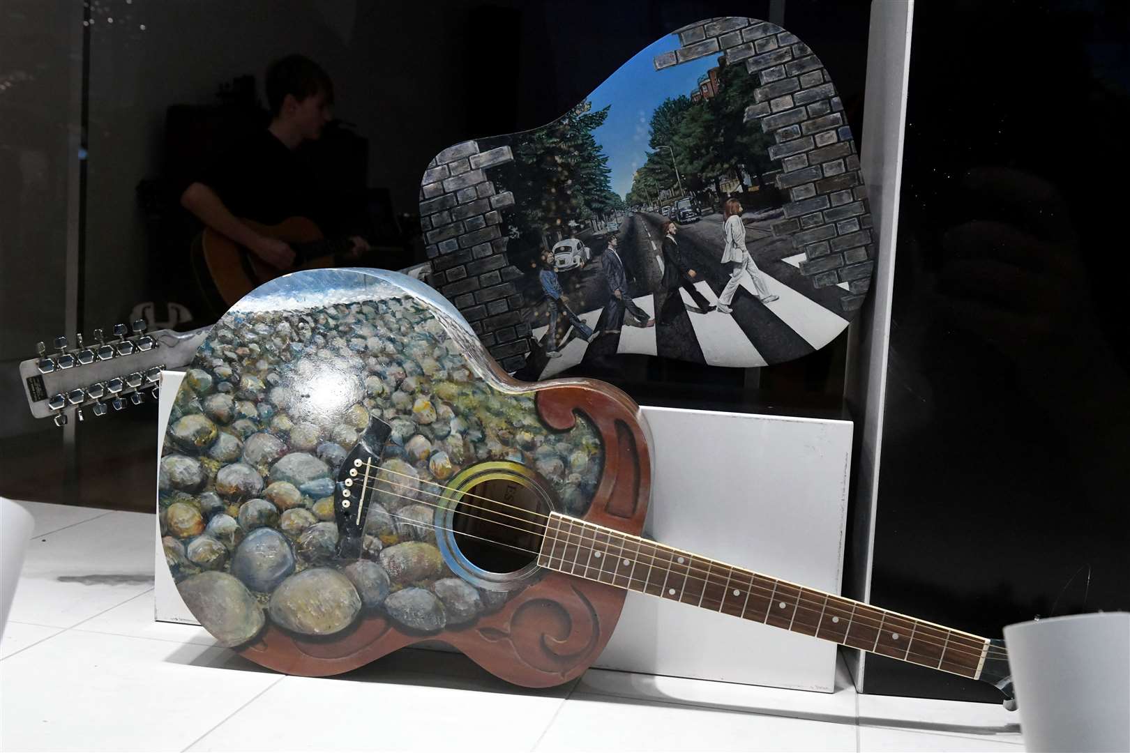 The iconic Abbey Road album cover by The Beatles is depicted on a hand-painted guitar. Picture: James Mackenzie.