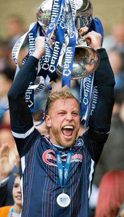 Ross County captain Andrew Davies lifts the Scottish League Cup after his side saw off Hibs 2-1 in the Hampden final.