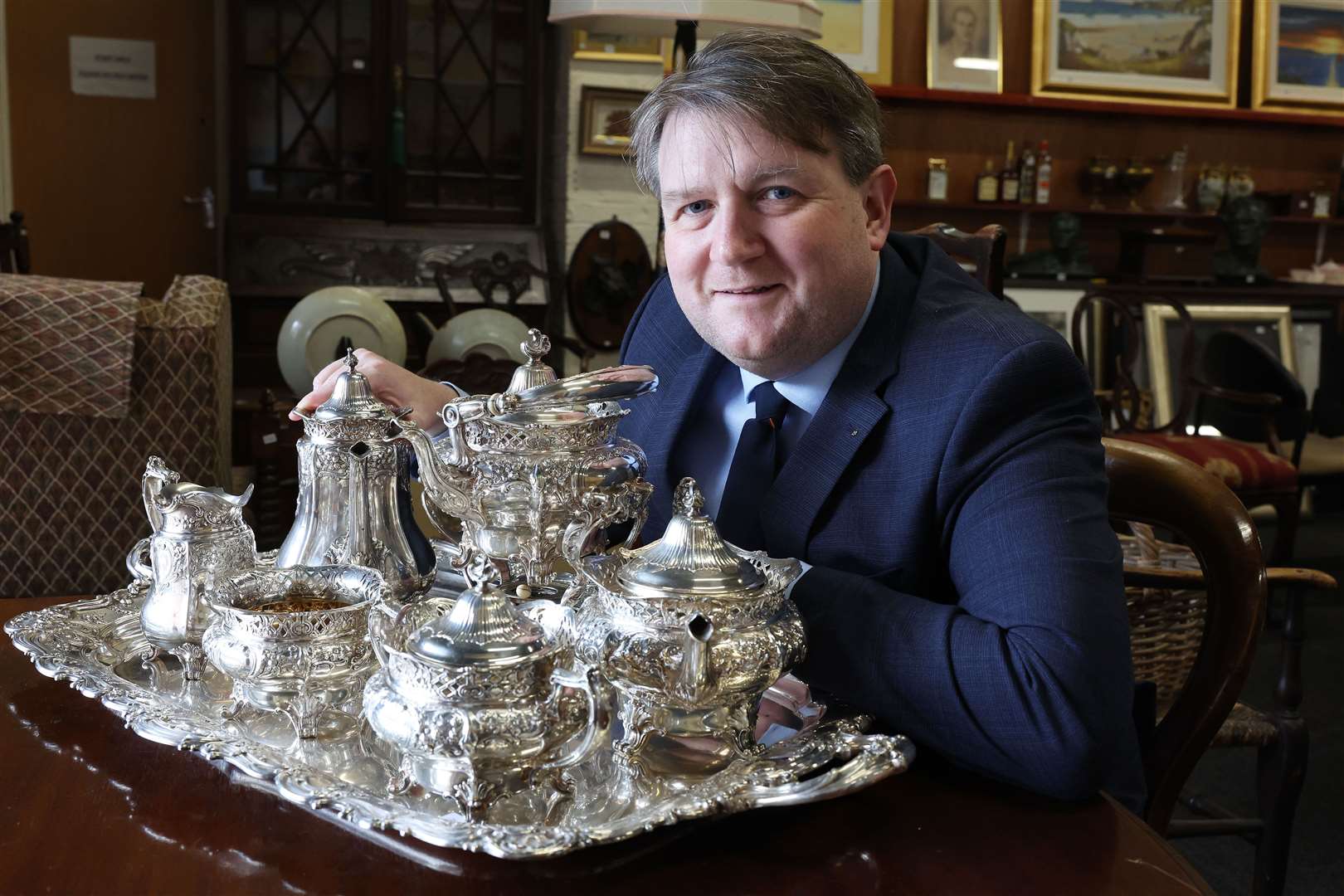 The managing director of Bloomfield Auctions, Karl Bennett shows off a silver tea service (BloomfieldAuctions/pressEye/PA)