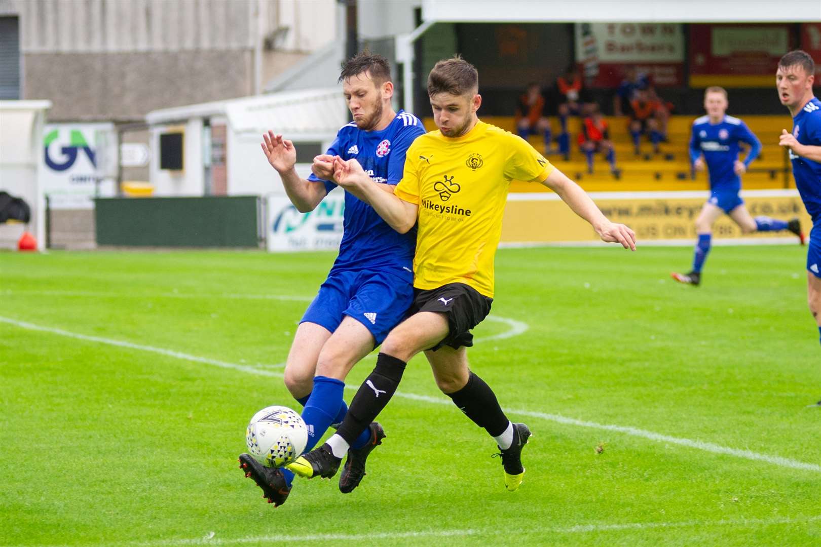 Nairn County's Dylan MacKenzie and Lossiemouth centre back Dean Stewart chase down the ball. ..Nairn County FC (2) vs Lossiemouth FC (4) - North of Scotland Cup first round - Station Park, Nairn 28/07/2021...Picture: Daniel Forsyth..