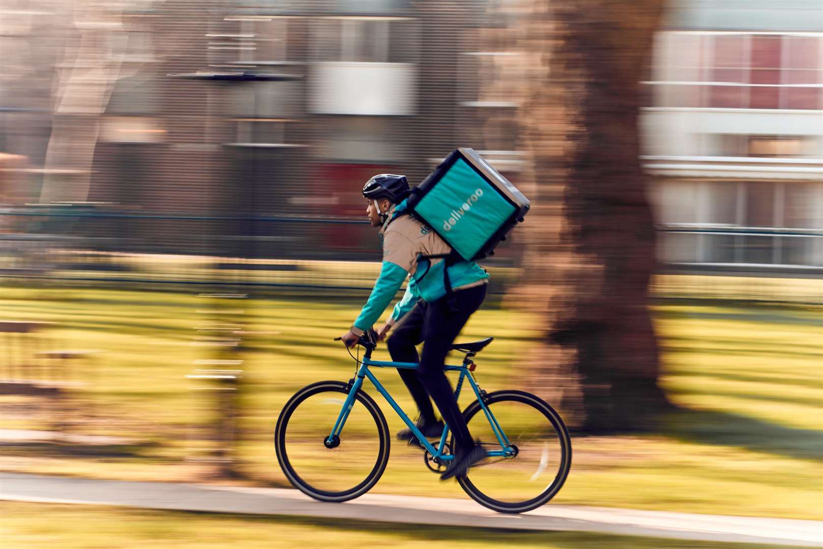 Deliveroo employees take food to people.